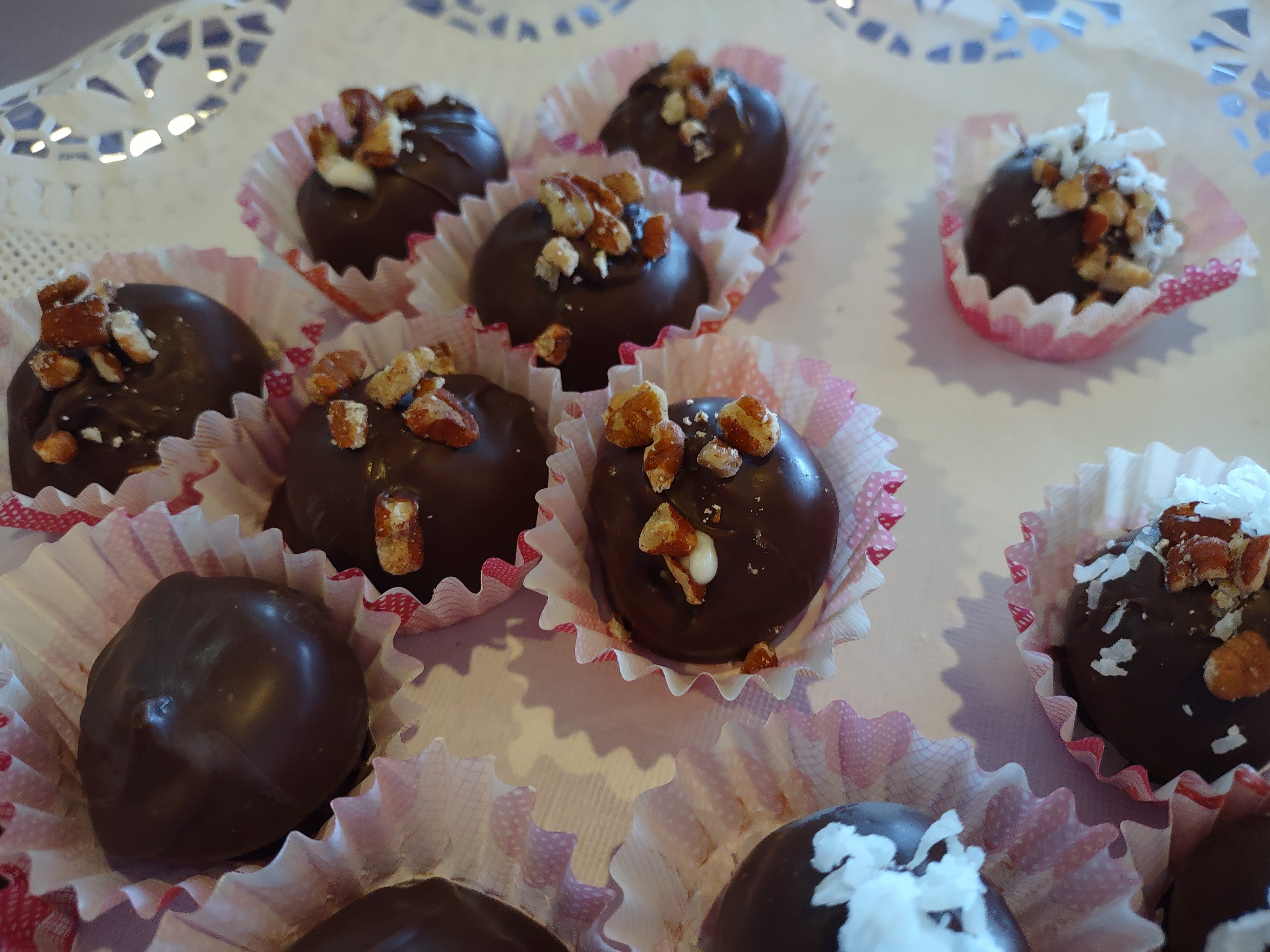 Handcrafted dark chocolates topped with pecan pieces and coconut