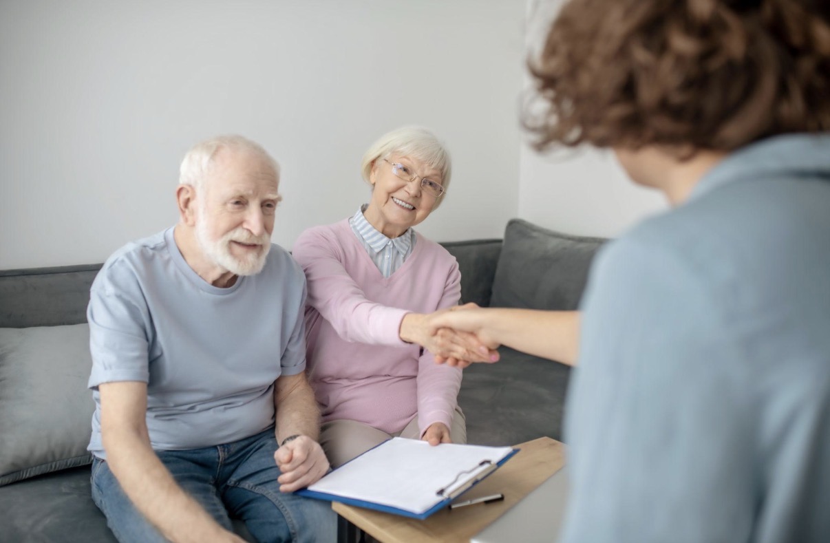Senior couple meeting with their trusted Medicare advisor — warm, relaxed home setting