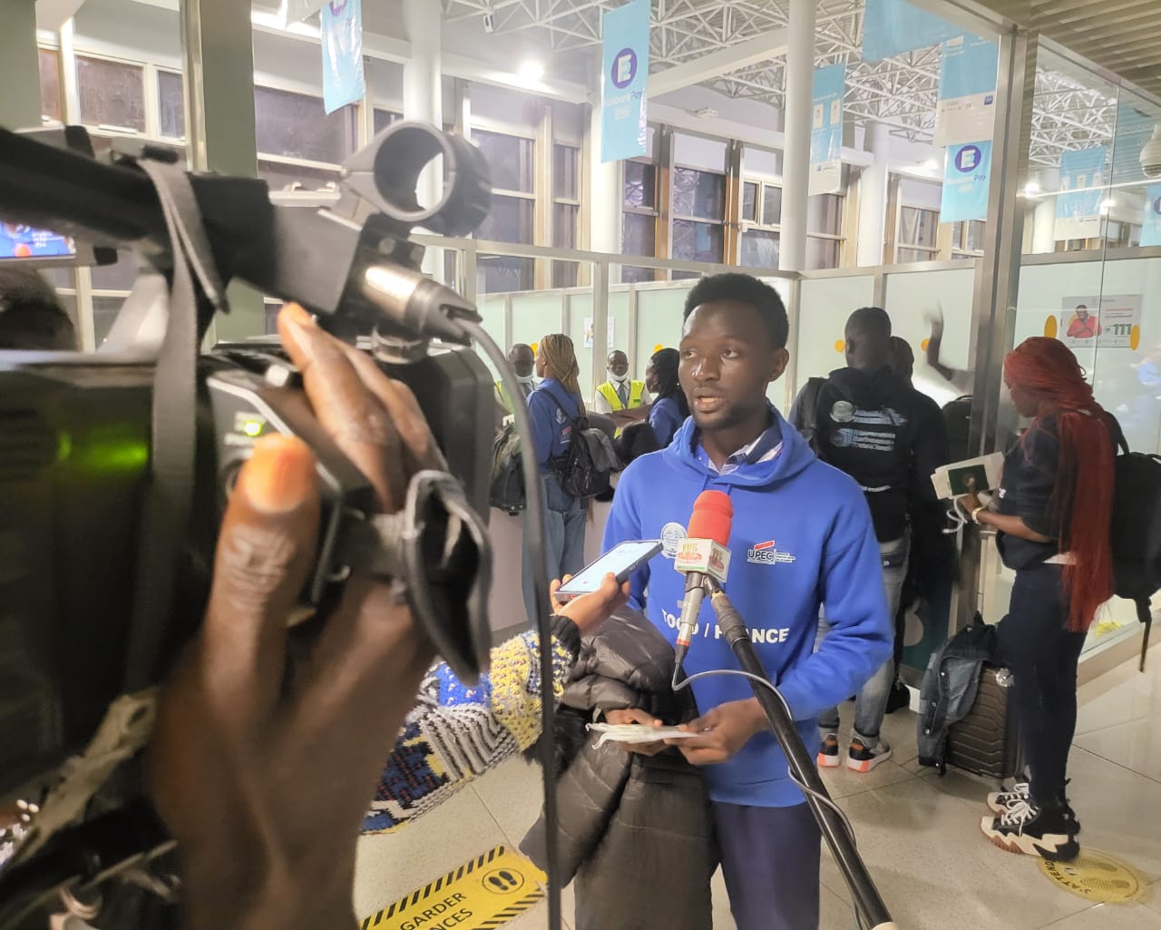 Étudiant ESIG en hoodie TOGO/FRANCE interviewé par presse