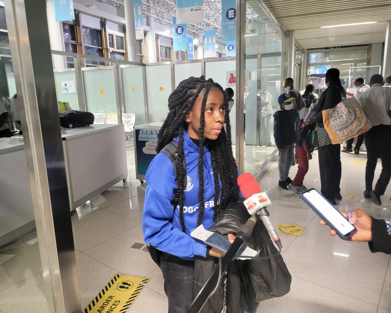 Étudiante ESIG en hoodie bleu interviewée presse aéroport