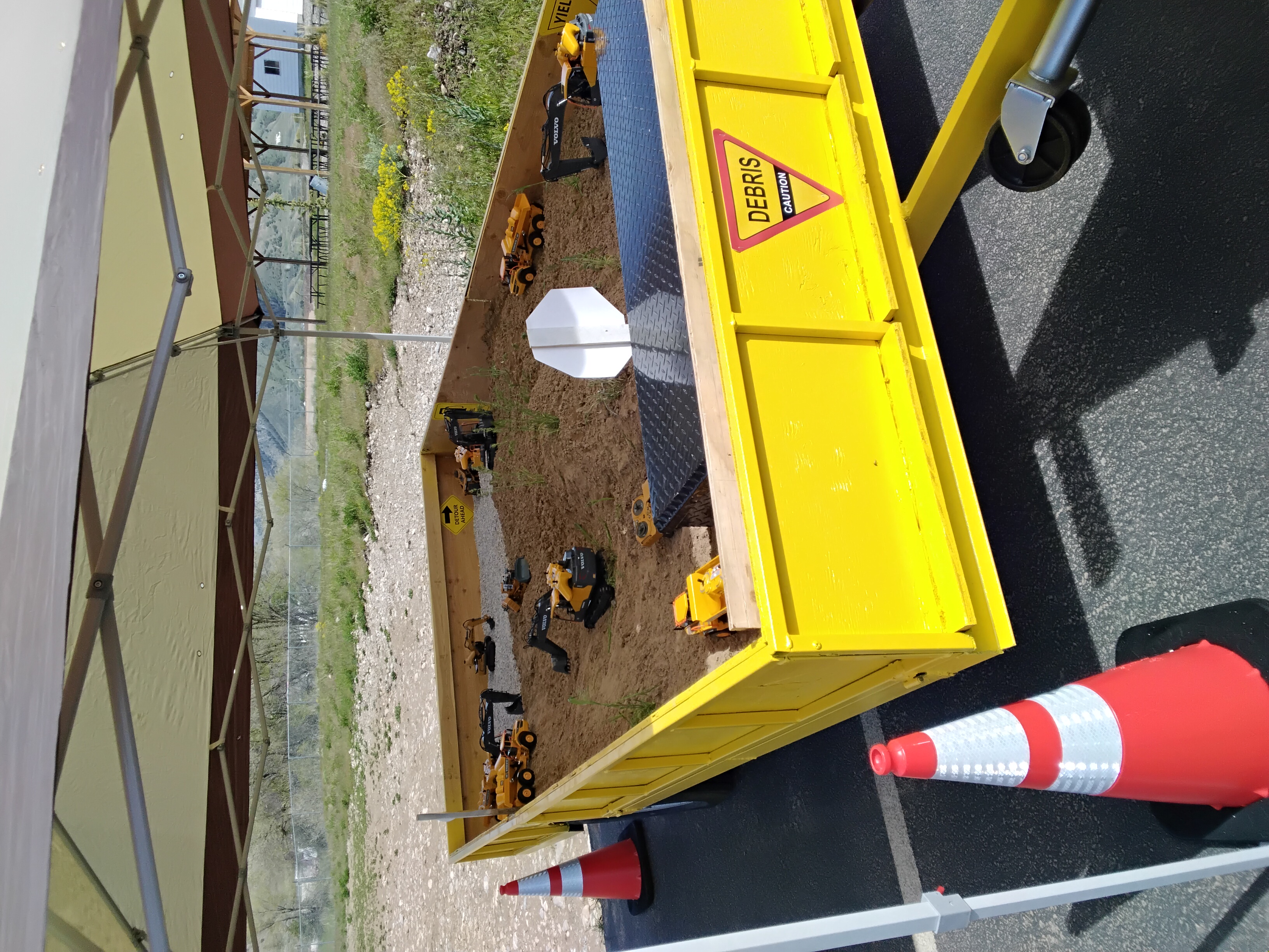 Overhead view of the Sand Castle Station trailer showing white sand, RC construction toys, and construction signs