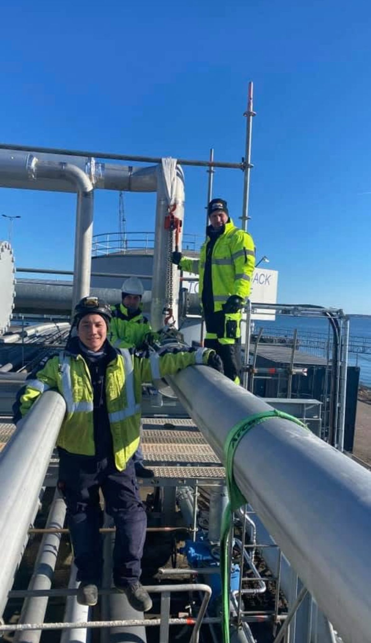 Équipe Selkom de tuyauteurs sur site industriel — 3 techniciens EPI haute visibilité sur plateforme tuyauterie