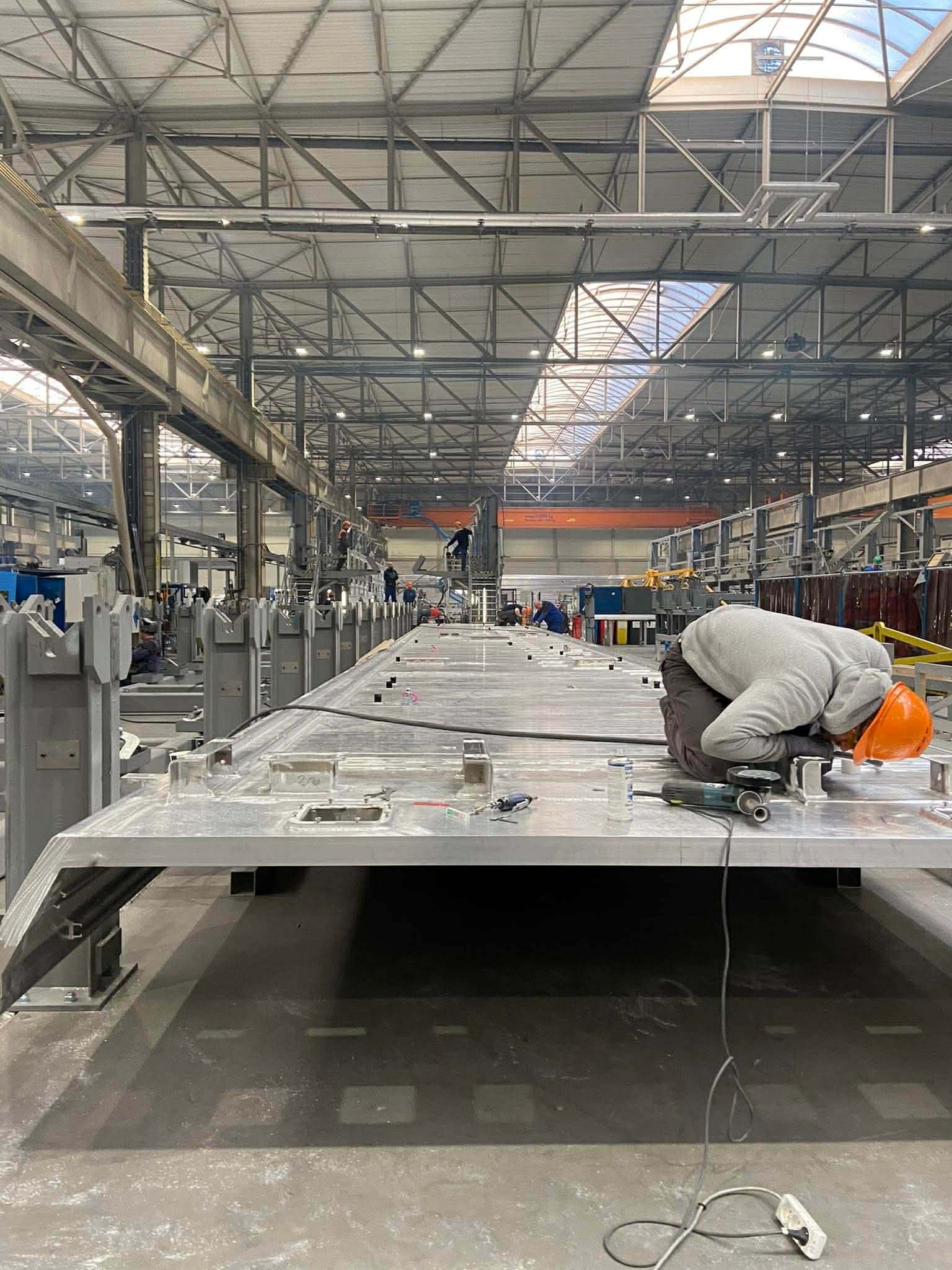 Ouvrier casque orange sur châssis alu — travail de précision