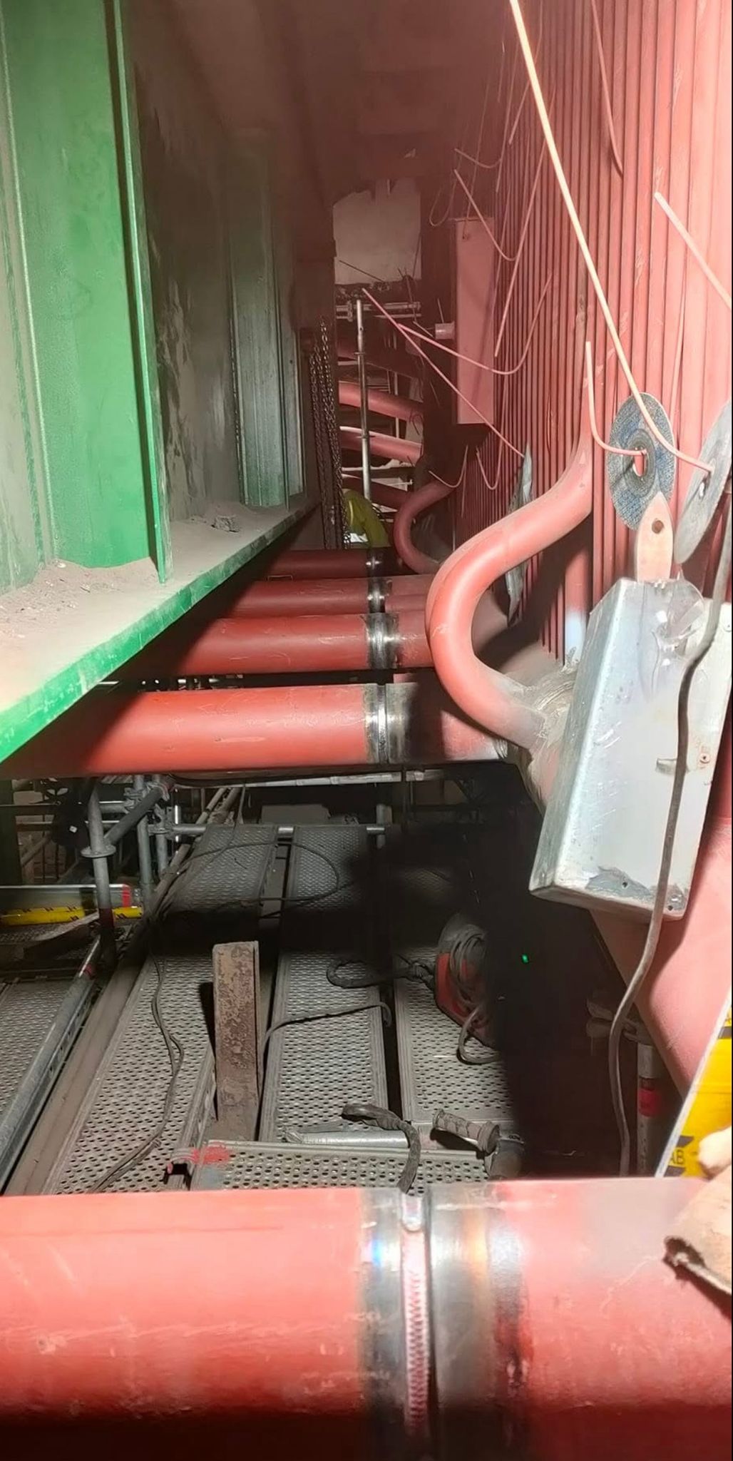 Réseau de tuyauterie en cours d'installation — vue en perspective tuyaux rouges sur site industriel