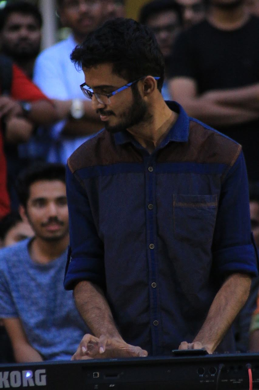 Yashodeep playing KORG keyboard at a live gig with audience watching