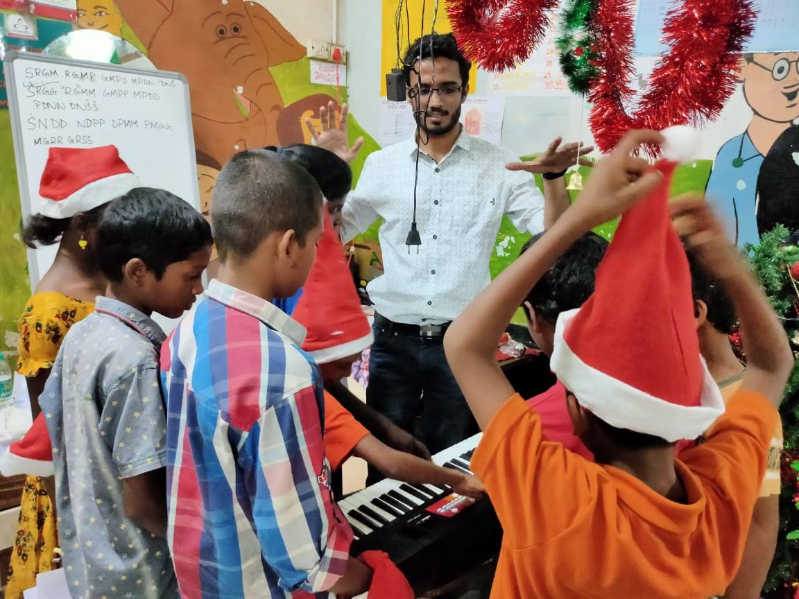 Yashodeep teaching piano to children at OneLife, Bangalore 2019, SRGM notation on whiteboard