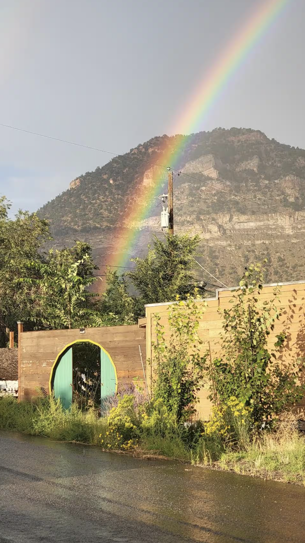 Hobbit door entrance with rainbow arcing over Helper mountains — The Old Company Store