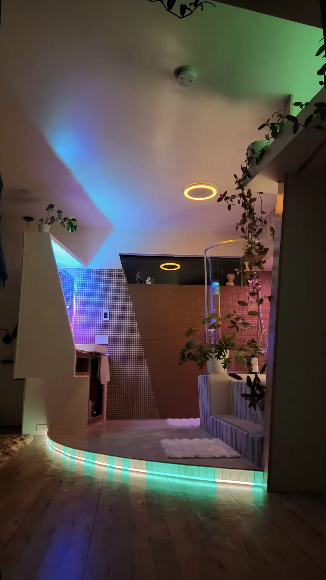 Zen spa bathroom at night — LED ambiance, mosaic tile, dramatic blue-green lighting