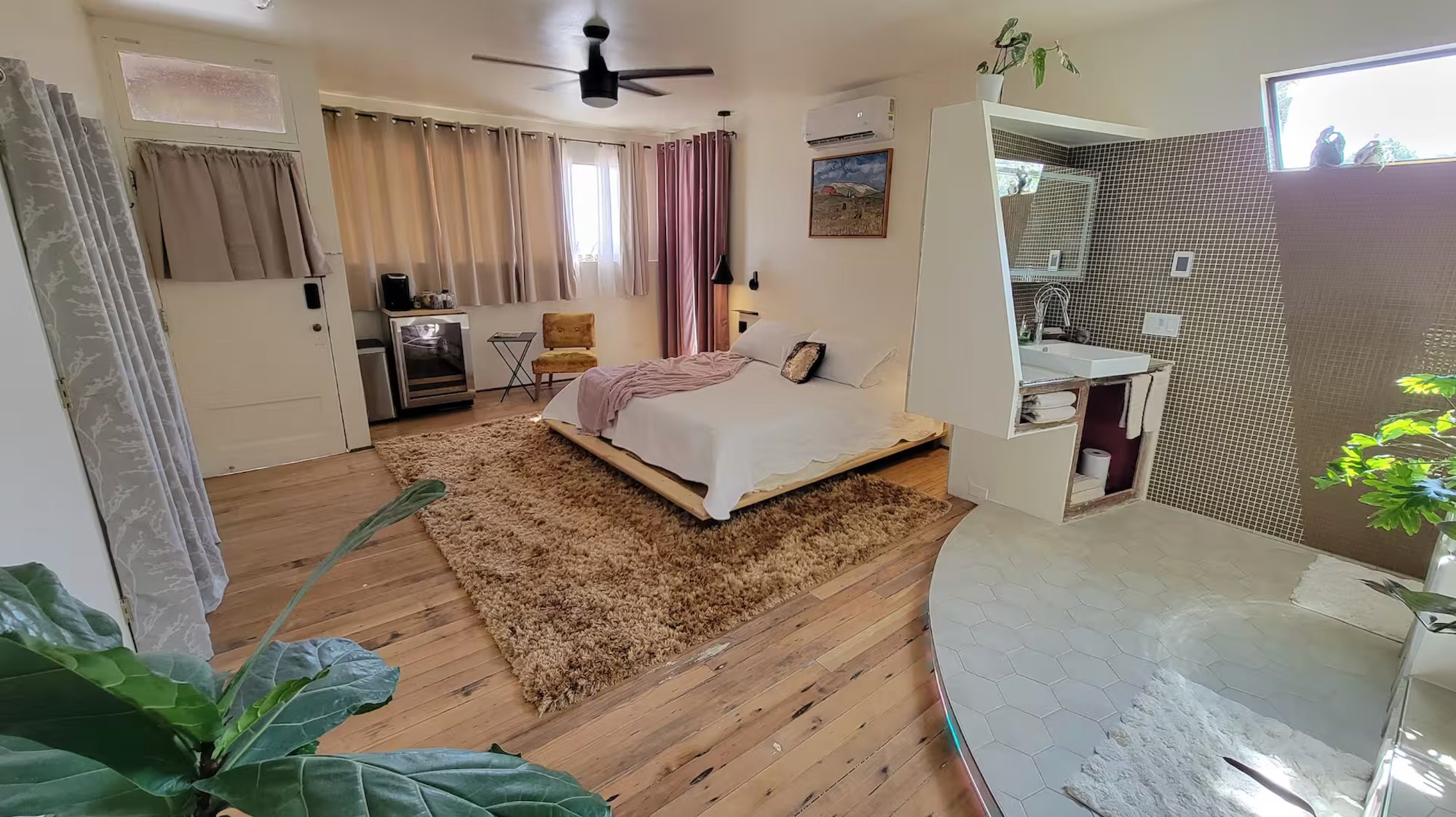 Bedroom wide shot — platform bed, shag rug, open spa bathroom visible