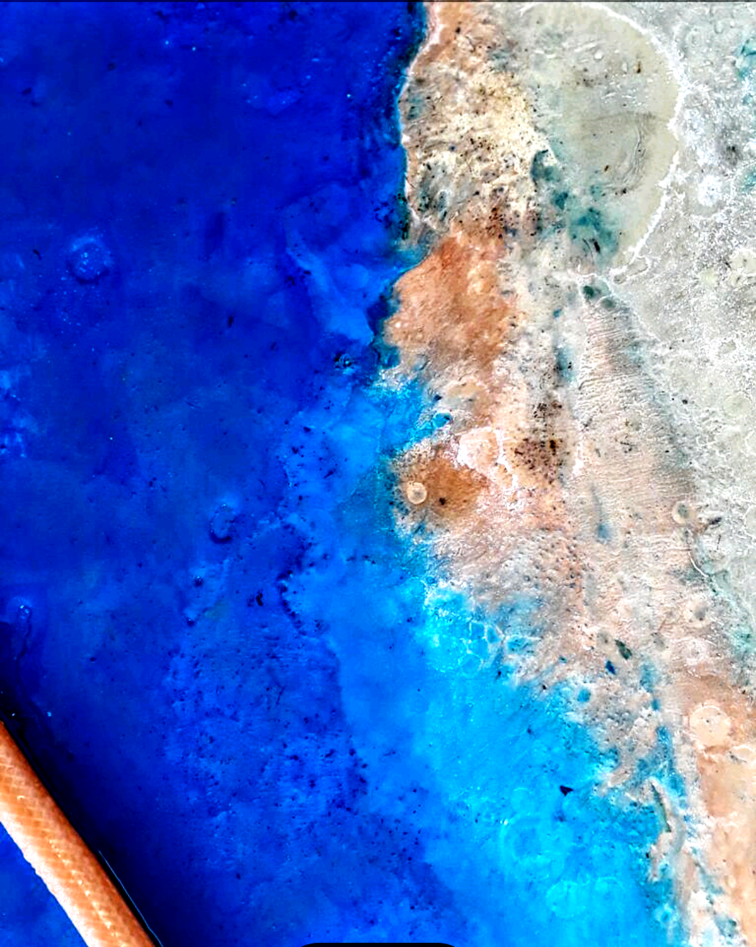 Vivid blue metallic epoxy detail — blue and copper ocean effect, close-up