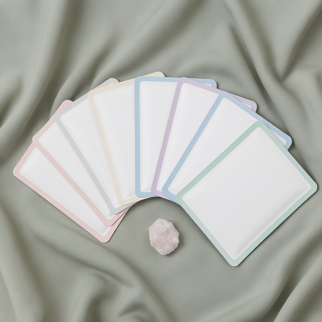7-Day Glow Kit — seven sheet masks fanned out on sage linen, rose quartz accent